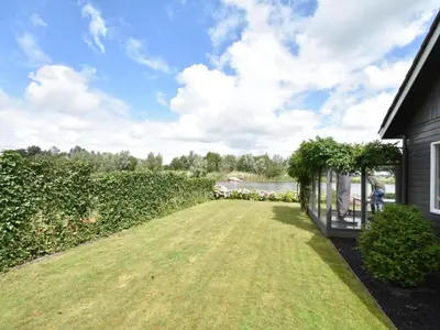 a backyard with a lawn and a house at Riverside holiday home near Amsterdam in Nigtevecht