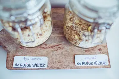 two jars of food on a wooden cutting board at Bed & Breakfast De Ruige Weide in Oudewater