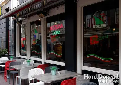 a restaurant with tables and chairs in front of a window at Hotel Doria in Amsterdam