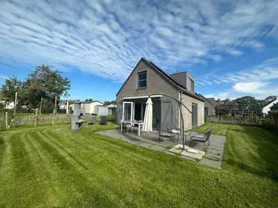 a house with a yard with a grass field at De Wielen 58 in Sint Maarten