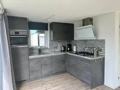 a kitchen with gray cabinets and a counter top at De Wielen 58 in Sint Maarten