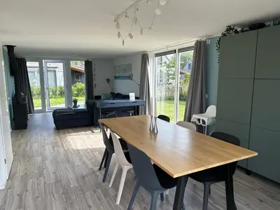 a living room with a wooden table and chairs at De Wielen 58 in Sint Maarten