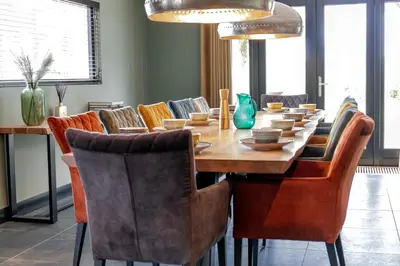 a dining room with a wooden table and chairs at Villa aan 't Wiel op Recreatiepark De Wielen in Sint Maarten