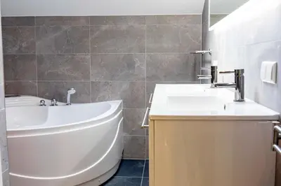 a bathroom with a sink and a tub and a toilet at Villa aan 't Wiel op Recreatiepark De Wielen in Sint Maarten