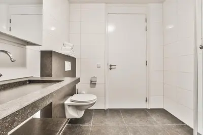 a white bathroom with a toilet and a shower at Appartement met frontaal zeezicht in Bloemendaal in Bloemendaal
