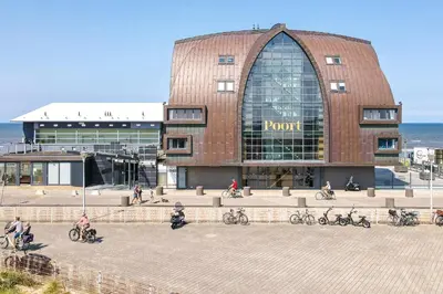a pivot building with bikes parked outside of it at Appartement met frontaal zeezicht in Bloemendaal in Bloemendaal