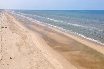 an overhead view of a beach with people on it at Appartement met frontaal zeezicht in Bloemendaal in Bloemendaal