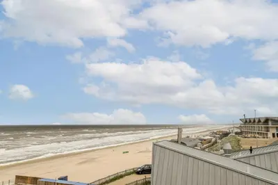 a view of the beach from the balcony of a condo at Appartement met frontaal zeezicht in Bloemendaal in Bloemendaal