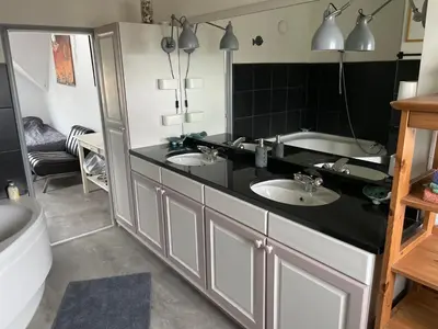 a bathroom with two sinks and a black counter at Cosy appartment in Alkmaar