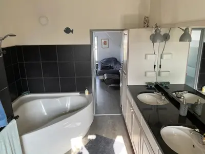a bathroom with a tub and two sinks and a bath tub at Cosy appartment in Alkmaar