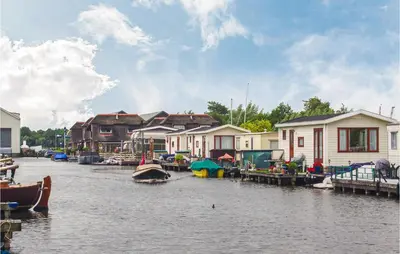 a group of houses and boats on a river at 2 Bedroom Lovely Home In Breukelen in Breukelen