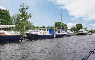 a group of boats are docked in a river at 2 Bedroom Lovely Home In Breukelen in Breukelen