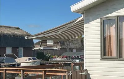 a house with chairs and a table and a boat at 2 Bedroom Lovely Home In Breukelen in Breukelen