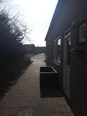 a brick sidewalk next to a building with a door at Huize Visser in Egmond aan Zee