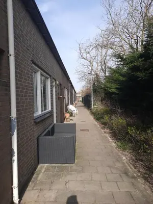 an empty sidewalk next to a brick building at Huize Visser in Egmond aan Zee