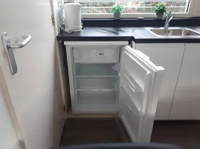 an empty refrigerator in a kitchen with a sink at Huize Visser in Egmond aan Zee
