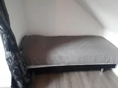 a bed sitting in a corner of a room at Huize Visser in Egmond aan Zee