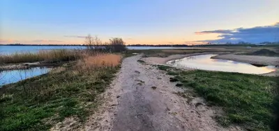 a dirt road next to a body of water at Inntermezzo in Almere