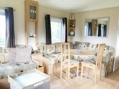 a living room with a table and chairs at Chalet 575 op Recreatiepark De Wielen in Sint Maarten