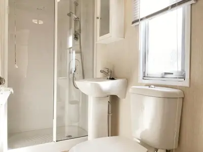 a bathroom with a toilet and a sink and a shower at Chalet 575 op Recreatiepark De Wielen in Sint Maarten
