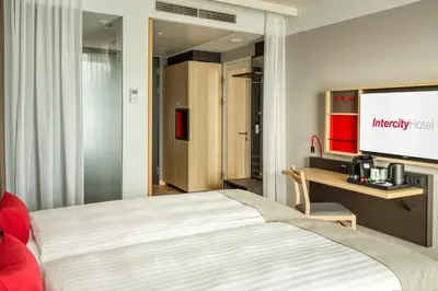 a hotel room with a bed and a tv at IntercityHotel Amsterdam Schiphol Airport in Hoofddorp