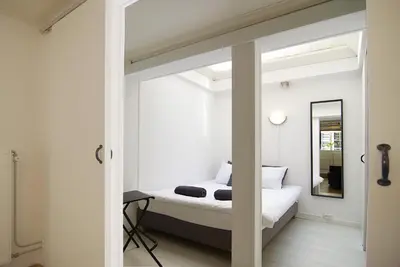 a bedroom with a bed and a mirror at Cosy apartment right in the city center with AIRCO! in Amsterdam