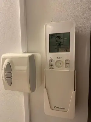 a white thermostat on a wall next to a dispenser at Cosy apartment right in the city center with AIRCO! in Amsterdam