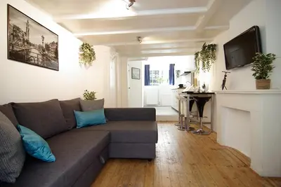a living room with a couch and a fireplace at Cosy apartment right in the city center with AIRCO! in Amsterdam