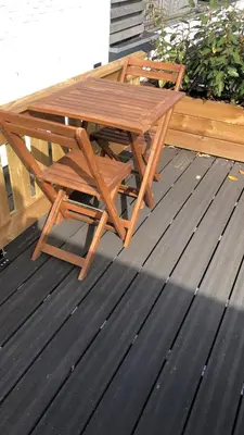 a wooden picnic table and chair on a deck at Thomasloft in Oegstgeest
