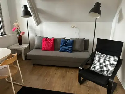 a living room with a couch with colorful pillows at Thomasloft in Oegstgeest
