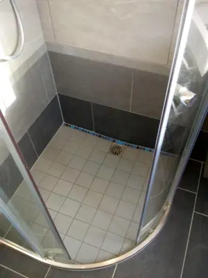 a shower with a glass door and a white tile floor at ALDO, not for parties, not a hotel, room with shared bathroom, no kitchen in Amsterdam