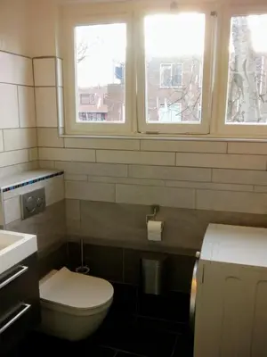 a bathroom with a toilet and two windows at ALDO, not for parties, not a hotel, room with shared bathroom, no kitchen in Amsterdam
