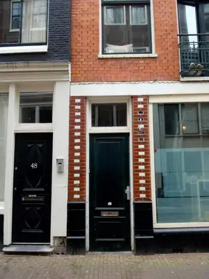 two black doors on the side of a brick building at ALDO, not for parties, not a hotel, room with shared bathroom, no kitchen in Amsterdam