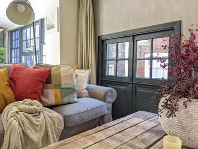 a living room with a couch and a wooden table at LaneStay DamSquare in Amsterdam