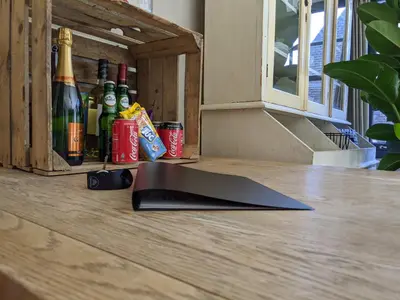 a computer keyboard sitting on a table with bottles of wine at LaneStay DamSquare in Amsterdam