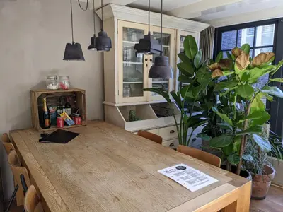 a wooden table in a kitchen with a large plant at LaneStay DamSquare in Amsterdam
