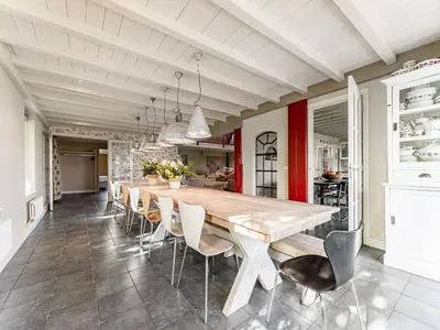 a dining room with a large wooden table and chairs at Spacious Holiday home De Pauwenhof in Heiloo