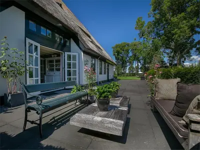 a green bench sitting outside of a house at Spacious Holiday home De Pauwenhof in Heiloo