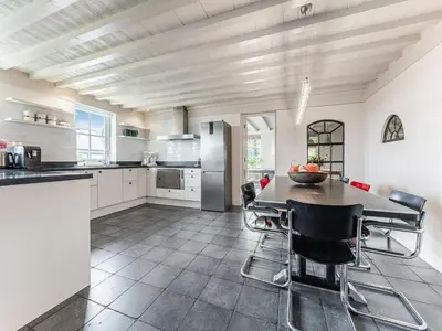 a kitchen with a table and chairs in it at Spacious Holiday home De Pauwenhof in Heiloo