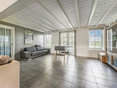 a living room with a couch and a piano at Spacious Holiday home De Pauwenhof in Heiloo