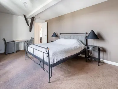 a bedroom with a bed and a table and a lamp at Spacious Holiday home De Pauwenhof in Heiloo