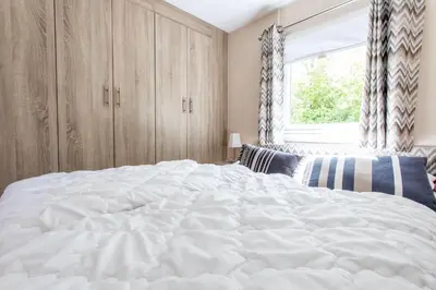 a large white bed in a bedroom with a window at Chalet 2a op Recreatiepark De Wielen in Sint Maarten