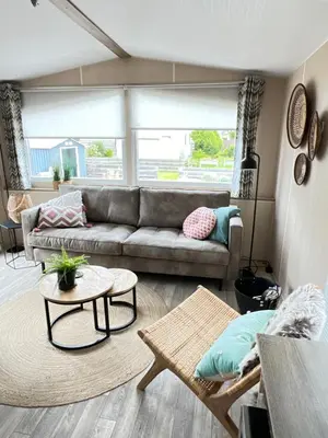 a living room with a couch and a table at Chalet 2a op Recreatiepark De Wielen in Sint Maarten