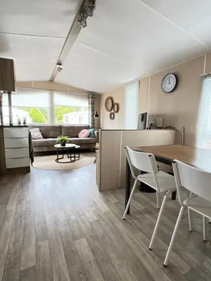 a kitchen and living room with a table and chairs at Chalet 2a op Recreatiepark De Wielen in Sint Maarten