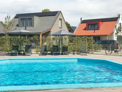 a swimming pool in front of a house at Chalet 3a op Recreatiepark De Wielen in Sint Maarten