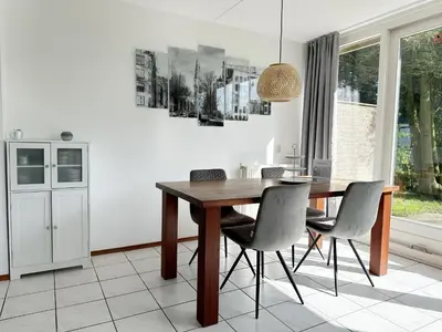 a dining room with a wooden table and chairs at Bungalow 36 op Recreatiepark De Wielen in Sint Maarten