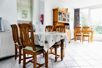 a dining room with a table and chairs at Bungalow 40 op Recreatiepark De Wielen in Sint Maarten