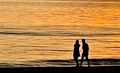 a couple walking on the beach at sunset at City room in Alkmaar