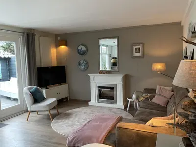 a living room with a couch and a tv at Appelbloesem in Bergen