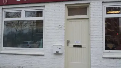 a white brick building with a door with numbers on it at Wellness Suite Utrecht in Utrecht